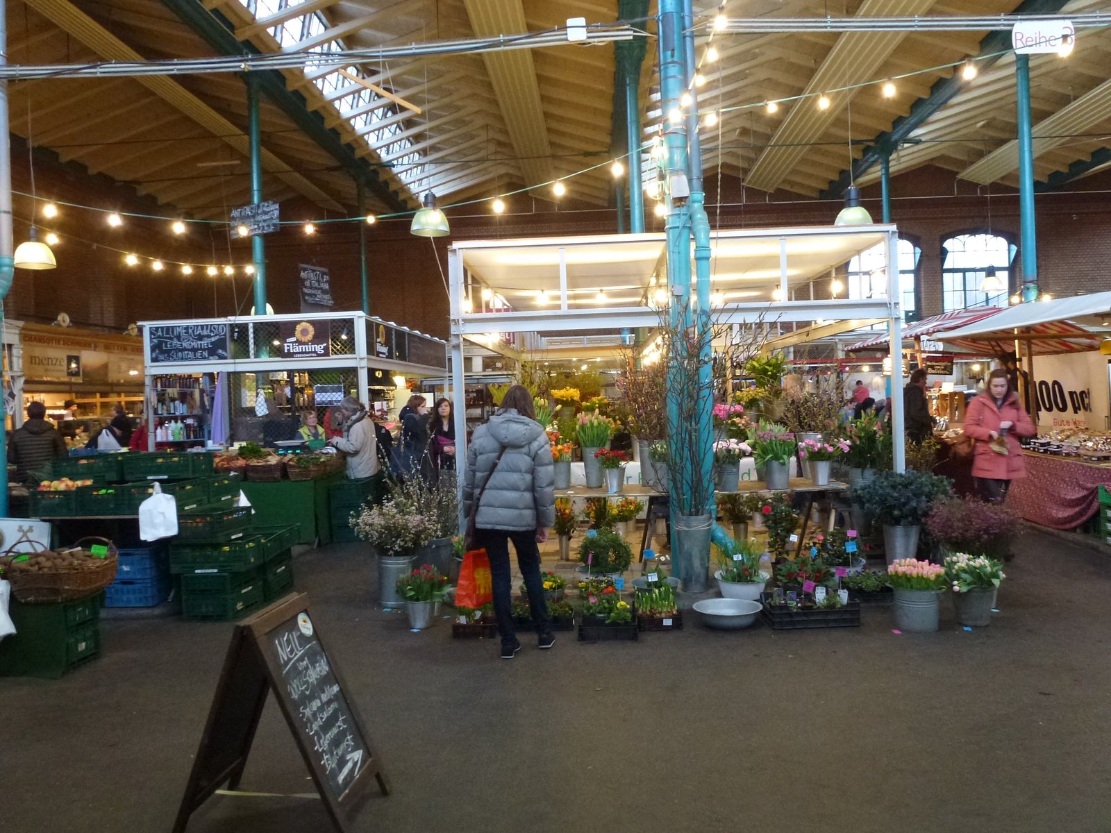 Market hall interior with stalls under string lights in Markthalle Neun, Berlin