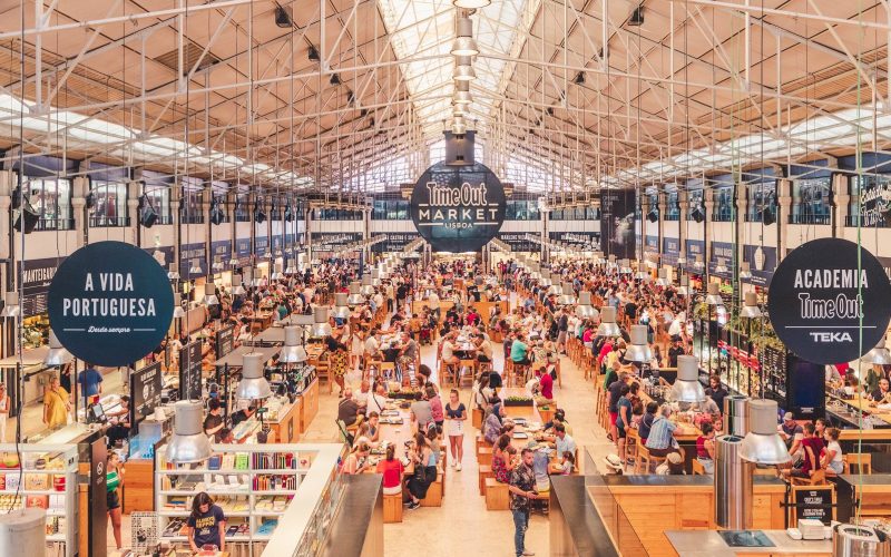Busy food hall under a steel roof at the Mercado da Ribeira in Lisbon