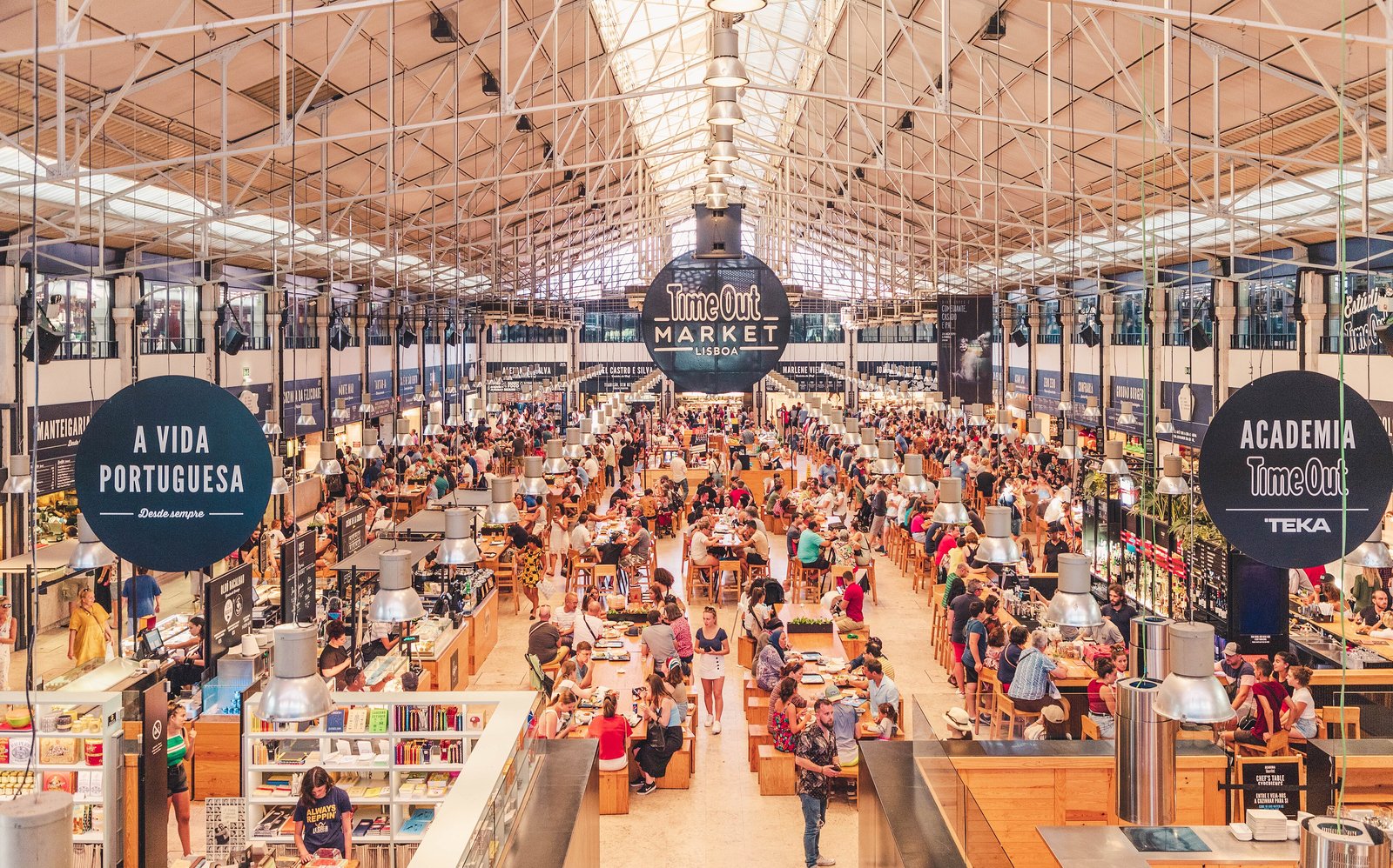Busy food hall under a steel roof at the Mercado da Ribeira in Lisbon