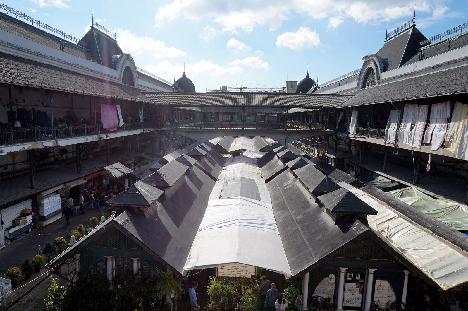 Courtyard of the Mercado do Bolhão with fruit and flower stalls under a blue sky in Porto