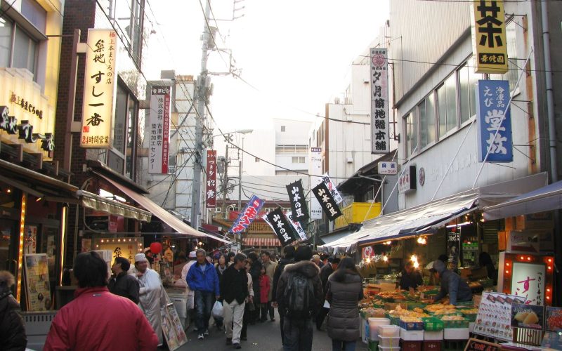 Busy lane of food stalls and restaurant signs in Tsukiji Outer Market, Tokyo