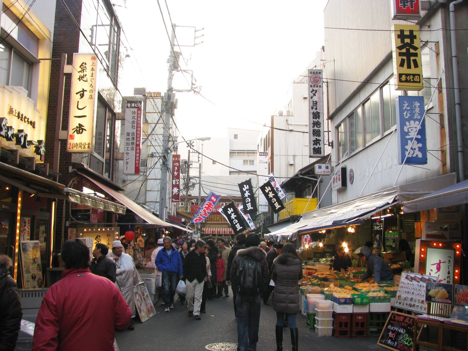 Busy lane of food stalls and restaurant signs in Tsukiji Outer Market, Tokyo